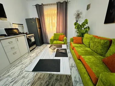a living room with a green couch and a table at Angie House Embassy area with wi fi in Hurghada