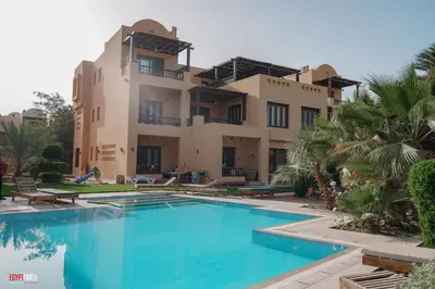 a villa with a swimming pool in front of a building at El Gouna South Marina 1 Bedroom Apartement with private Jacuzzi in Hurghada