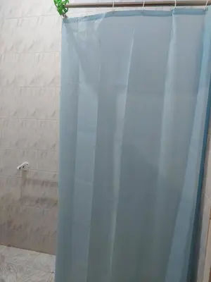 a bathroom with a shower with a blue shower curtain at Canary Hotel in Hurghada