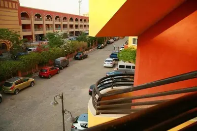 a parking lot with cars parked in front of a building at Esplanada Beach Apartment, no single men in Hurghada
