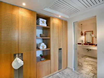 a bathroom with wooden shelves and a shower with a mirror at Movenpick Resort & Spa El Gouna in Hurghada