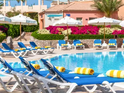 a pool with lounge chairs and umbrellas at a resort at Movenpick Resort & Spa El Gouna in Hurghada