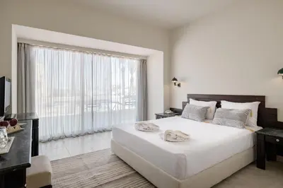 a bedroom with a large white bed and a large window at Sindbad Club in Hurghada
