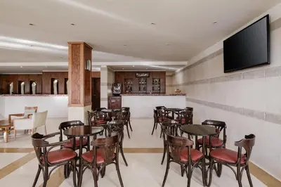 a restaurant with tables and chairs and a flat screen tv at Sindbad Club in Hurghada