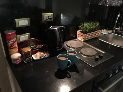 a kitchen counter with a coffee pot and cups on it at Pool View Apartment at British Resort - Unit 02 in Hurghada