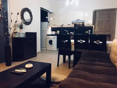 a living room with a couch and a kitchen at Pool View Apartment at British Resort - Unit 02 in Hurghada