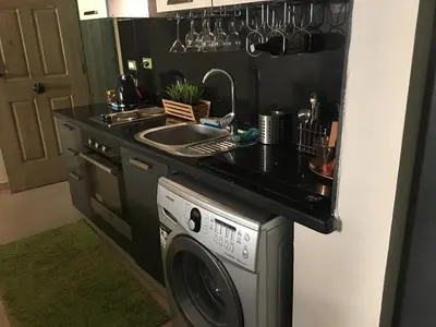 a kitchen with a sink and a washing machine at Pool View Apartment at British Resort - Unit 02 in Hurghada
