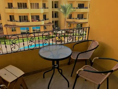 a table and chairs on a balcony with a view at Pool View Apartments at British Resort - Unit 13 in Hurghada
