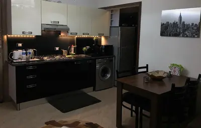 a kitchen with a stove and a sink and a table at Pool View Apartments at British Resort - Unit 13 in Hurghada