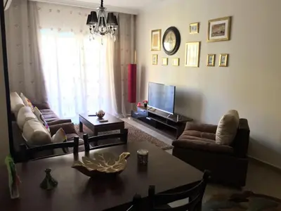 a living room with a table and a television at Pool View Apartments at British Resort - Unit 13 in Hurghada