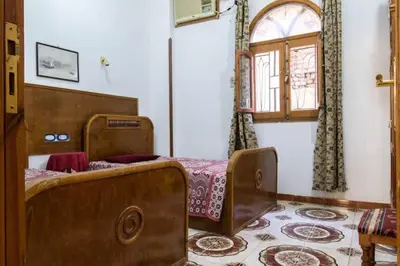 a bedroom with two beds and a window at Terrasses et Jardins sur le Nil chez Hagag rive Ouest in Luxor