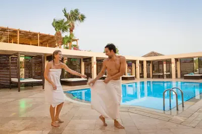 two women in white dresses standing by a swimming pool at Robinson Soma Bay in Hurghada