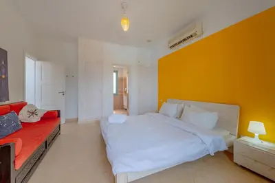 a bedroom with a large bed and a yellow wall at Stunning Villa for Rent in El Gouna HEATED PRIVATE POOL in Hurghada