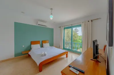 a bedroom with a bed and a tv and a window at Stunning Villa for Rent in El Gouna HEATED PRIVATE POOL in Hurghada
