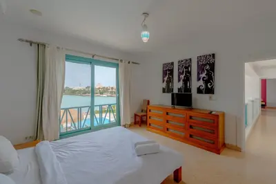 a bedroom with a bed and a tv and a window at Stunning Villa for Rent in El Gouna HEATED PRIVATE POOL in Hurghada
