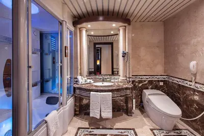 a bathroom with a tub and a toilet and a sink at Sonesta St. George Hotel - Convention Center in Luxor