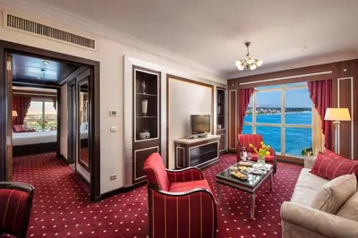 a living room with a couch and chairs and a television at Sonesta St. George Hotel - Convention Center in Luxor