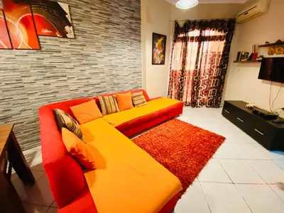 a living room with a red and yellow couch at Desert Pearl Apartment in Hurghada