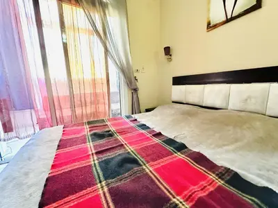 a bedroom with a large bed with a blanket on it at Desert Pearl Apartment in Hurghada