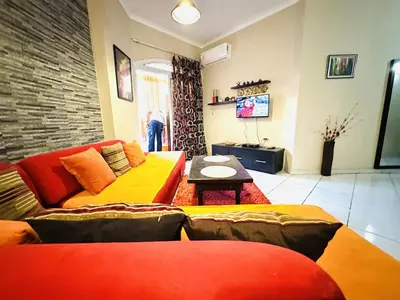 a living room with two couches and a table at Desert Pearl Apartment in Hurghada