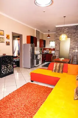 a living room with a colorful couch and a kitchen at Desert Pearl Apartment in Hurghada