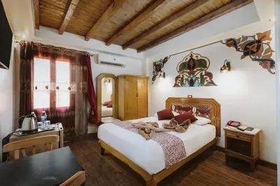 a bedroom with a large bed and a table at Nefertiti Hotel Luxor in Luxor