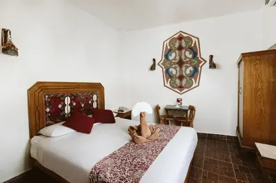 a bedroom with a bed with a stuffed animal on it at Nefertiti Hotel Luxor in Luxor