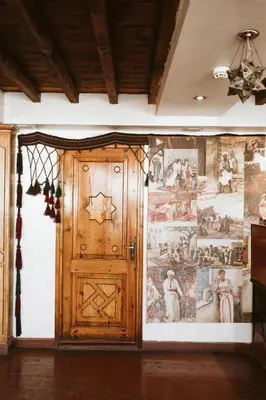 a room with a wooden door and a wall with paintings at Nefertiti Hotel Luxor in Luxor