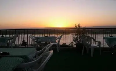 a table and chairs on a balcony with the sunset at St.Joseph Hotel in Luxor