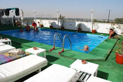a swimming pool with people playing in the water at St.Joseph Hotel in Luxor