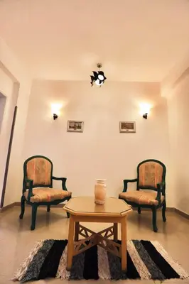 a living room with two chairs and a coffee table at Gold Ibis Hotel in Luxor