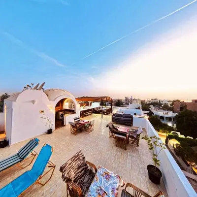 a patio with chairs and tables on top of a building at Gold Ibis Hotel in Luxor