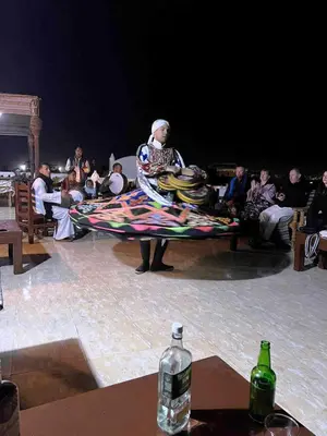 a man sitting on a bench with a blanket at Gold Ibis Hotel in Luxor