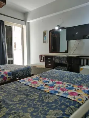 a hotel room with two beds and a flat screen tv at Windsor Hotel Luxor \u60a8\u5728\u76e7\u514b\u7d22\u7684\u7b2c\u4e8c\u500b\u5bb6 in Luxor