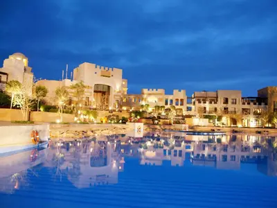 a swimming pool in front of a city at night at Pickalbatros The Palace Port Ghalib in Port Ghalib