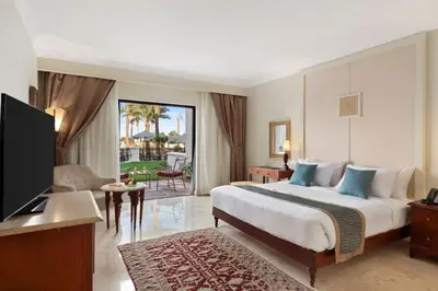 a hotel room with a large bed and a television at Pickalbatros The Palace Port Ghalib in Port Ghalib