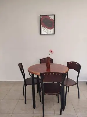 a wooden table and chairs with a vase on it at chalet Stella de Mari in Makadi Bey in Hurghada