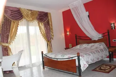 a bedroom with red walls and a bed with a canopy at chalet Stella de Mari in Makadi Bey in Hurghada