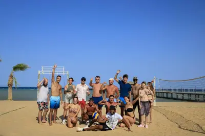 a group of people posing for a picture on the beach at Amwaj Beach Club Abu Soma in Hurghada