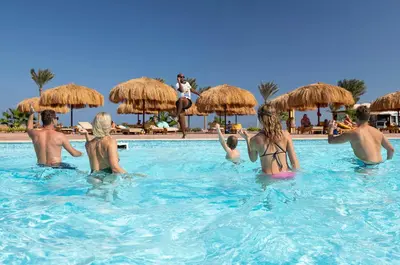 a group of people in the swimming pool at a resort at Three Corners Sea Beach Resort in Coraya Bay