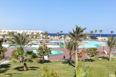 an aerial view of a resort pool with palm trees at Three Corners Sea Beach Resort in Coraya Bay