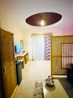 a living room with a ceiling with a room with a table at Jewel Howard Carter Hotel in Luxor