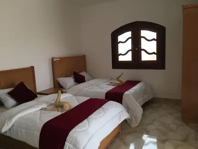three beds in a room with a window at Villamar Sea View rooms & apartments in Hurghada