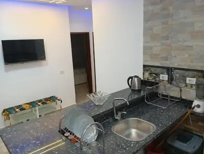 a kitchen counter with a sink and a tv on a wall at Villamar Sea View rooms & apartments in Hurghada