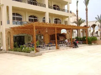 a building with tables and chairs in front of it at Apartment at Palm Beach Piazza in Hurghada