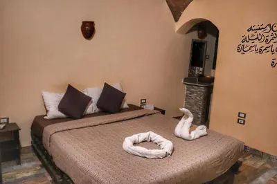 a bedroom with two beds with swans on them at Hadouta Masreya Nubian Guest House in Aswan