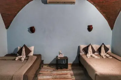 two beds in the corner of a room at Hadouta Masreya Nubian Guest House in Aswan