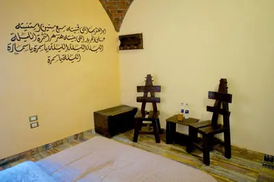 a bedroom with a bed and a desk and a chair at Hadouta Masreya Nubian Guest House in Aswan