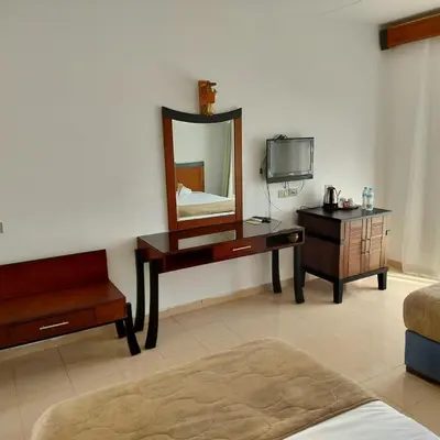 a room with a vanity and a mirror and a tv at Sharm El Naga Resort and Diving Center in Hurghada