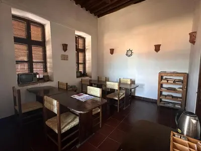 a dining room with tables and chairs and a tv at El Quseir Hotel in Quseir